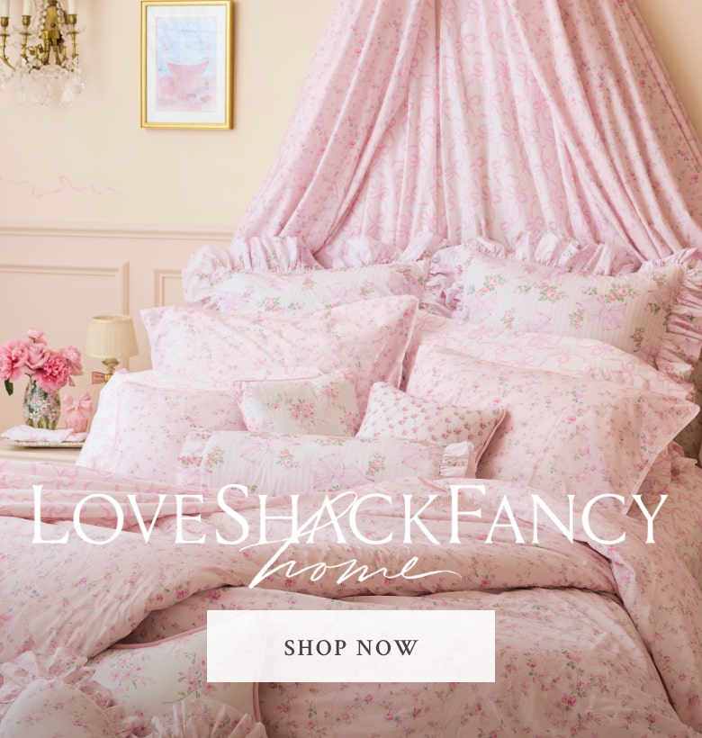 A bed with LoveShackFancy pillows, sheets, and covers. Shop Home.