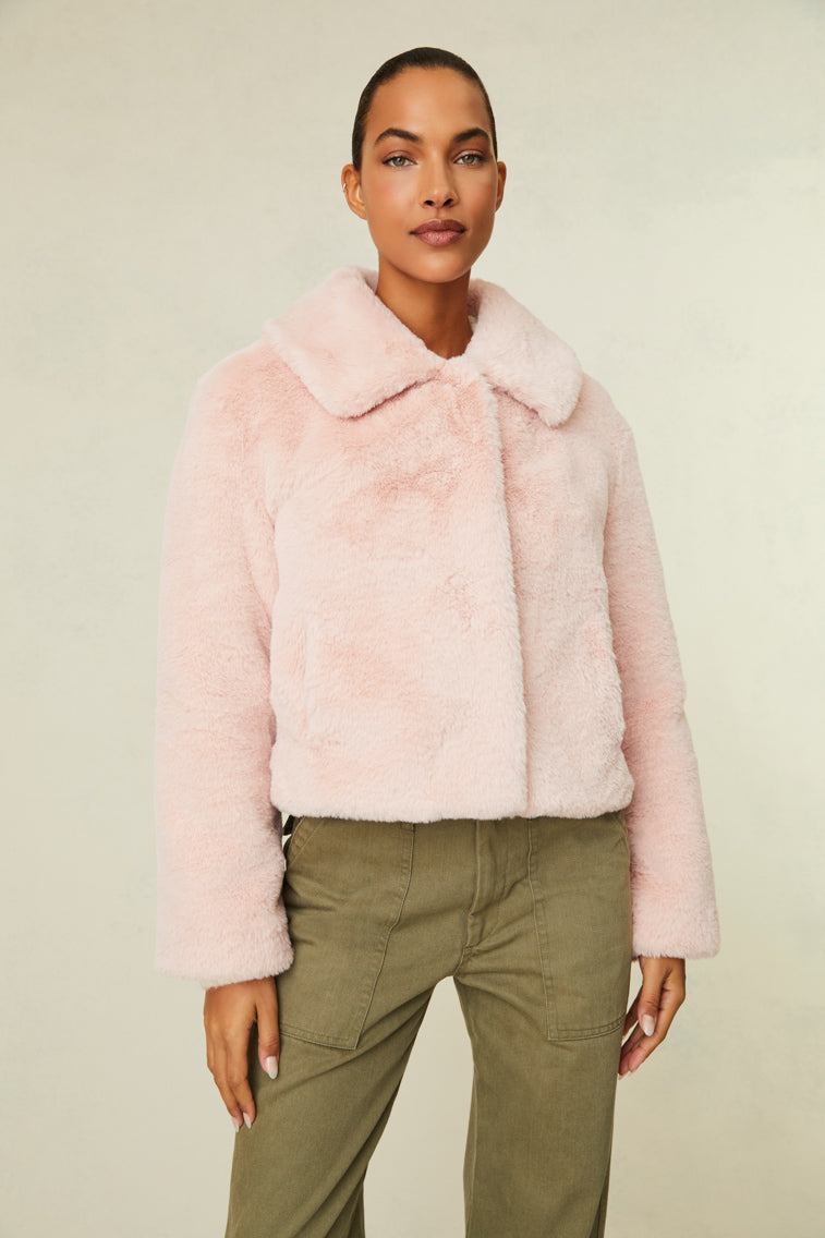 Faux fur jacket features a collar and functional buttons for closure.