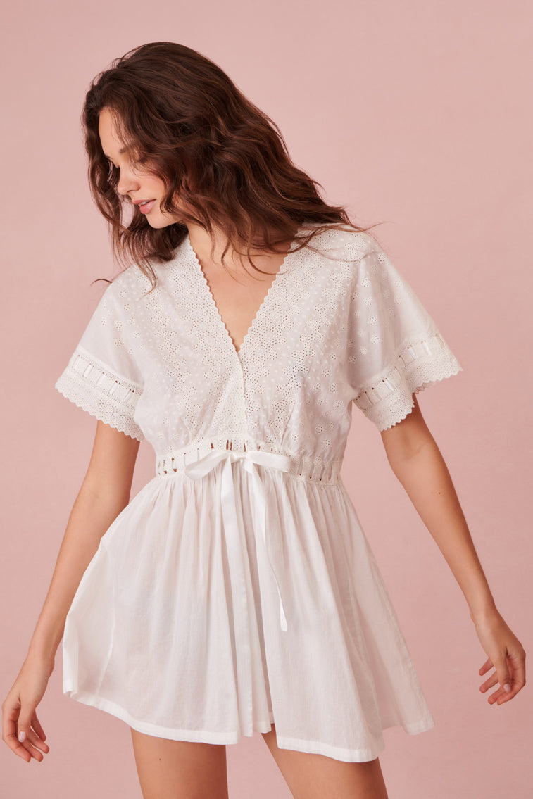 White babydoll nightgown has a delicate scalloped v-neckline, which overlaps at front above a threaded satin ribbon drawcord. 