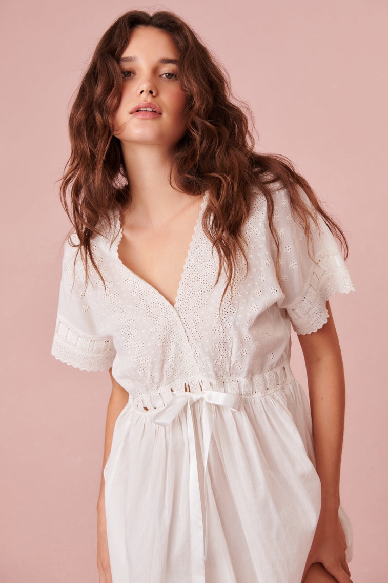 White babydoll nightgown has a delicate scalloped v-neckline, which overlaps at front above a threaded satin ribbon drawcord. 