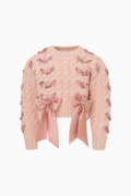 Girls' pink cable-knit cardigan close-up with large ribbon threaded through and bow at hem