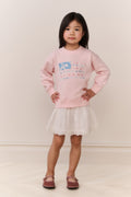 Little Girl wearing a pink american flag sweater and white skirt on a plain background