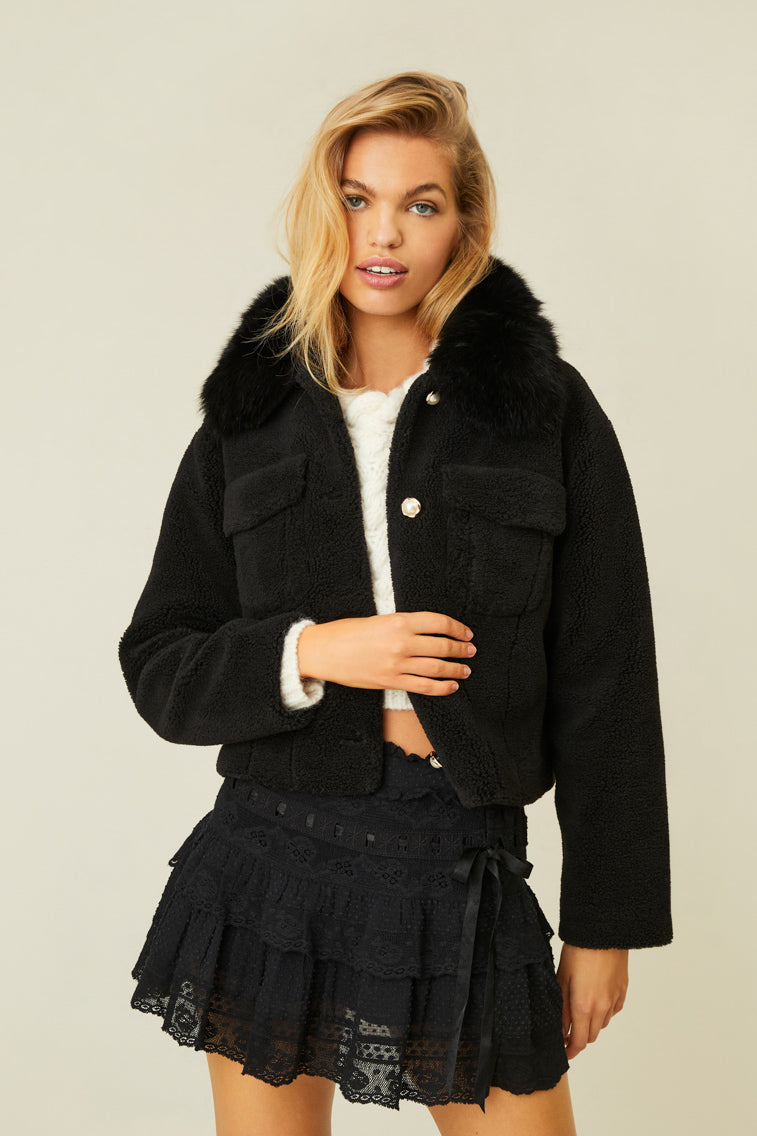 Black faux short-haired fur jacket, easy-to-wear shape, and a detachable real fox fur collar. With antique-inspired pearl buttons with gold trim. 