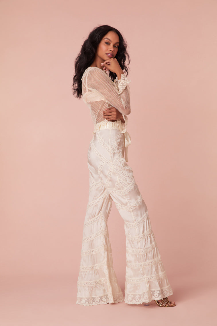 Floor length flare pants with laces and textural shirring details all over. Features a satin ribbon waistband with a self-tie.