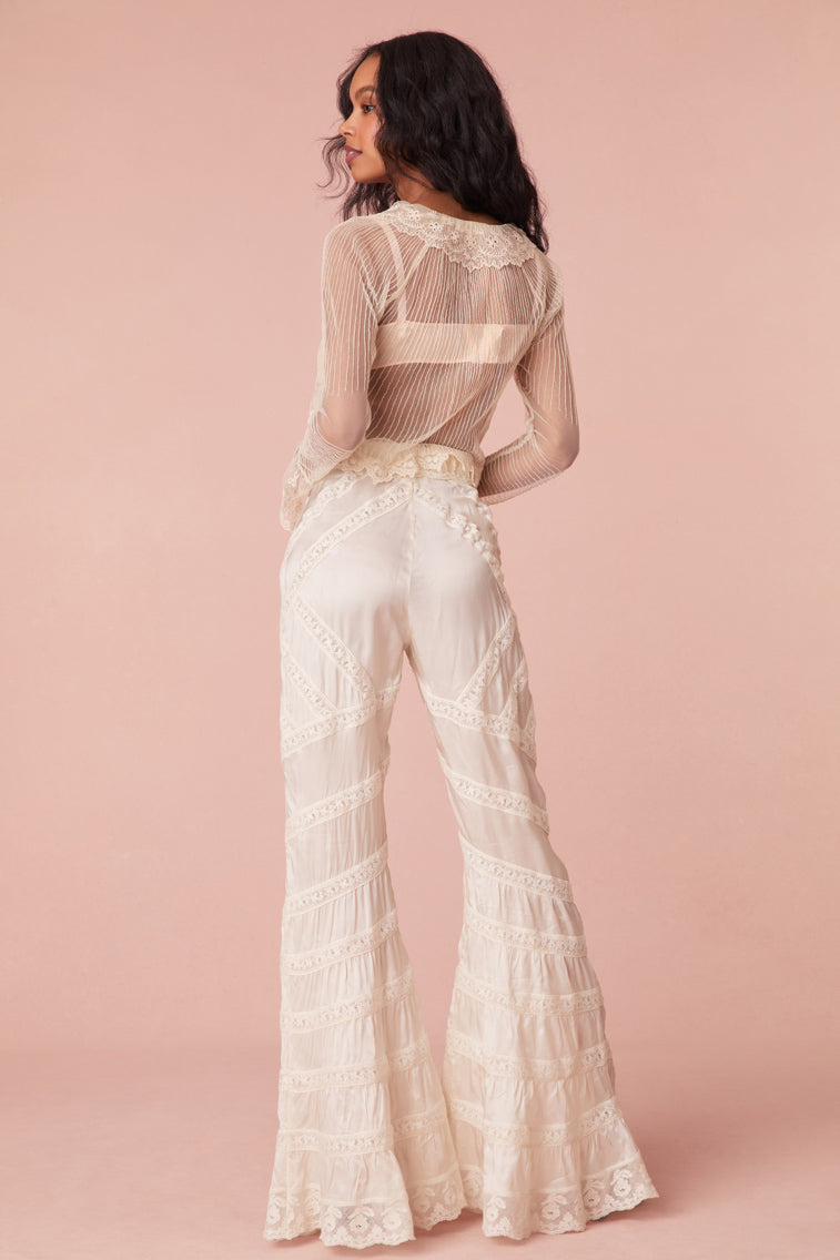 Floor length flare pants with laces and textural shirring details all over. Features a satin ribbon waistband with a self-tie.