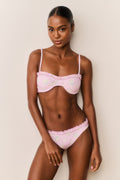 Woman wearing a pink floral bikini with a white background