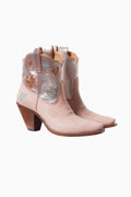 Pair of pink cowboy boots with heart designs on a white background