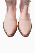 Pair of pink cowboy boots on a white background