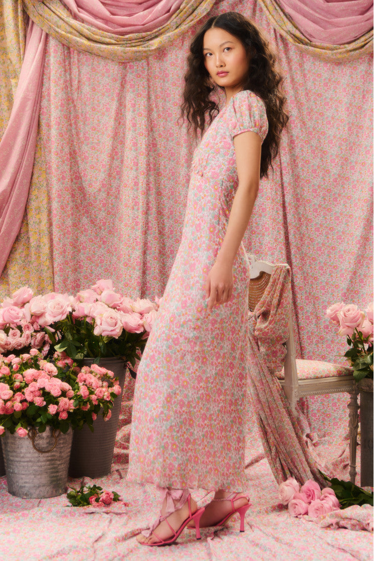 Two-toned floral printed maxi dress with short flutter sleeves, a deep v-neckline that descends to a tiny ruffle tier at the waistline before falling to a sweeping skirt.