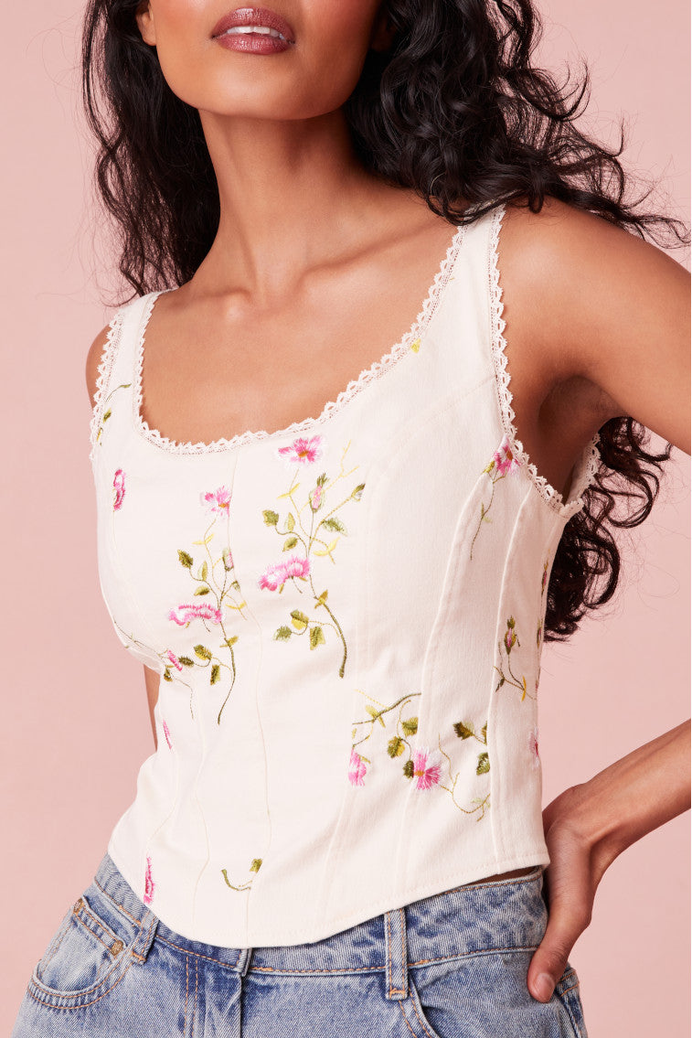 Pink floral bustier with a lace trim at the neckline, boning details for structure, and buttons for closure on the back.