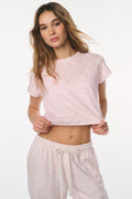 Woman wearing a pink lounge set with a white background