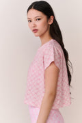 Woman wearing a pink bow patterned t-shirt and matching leggings outfit against a plain background