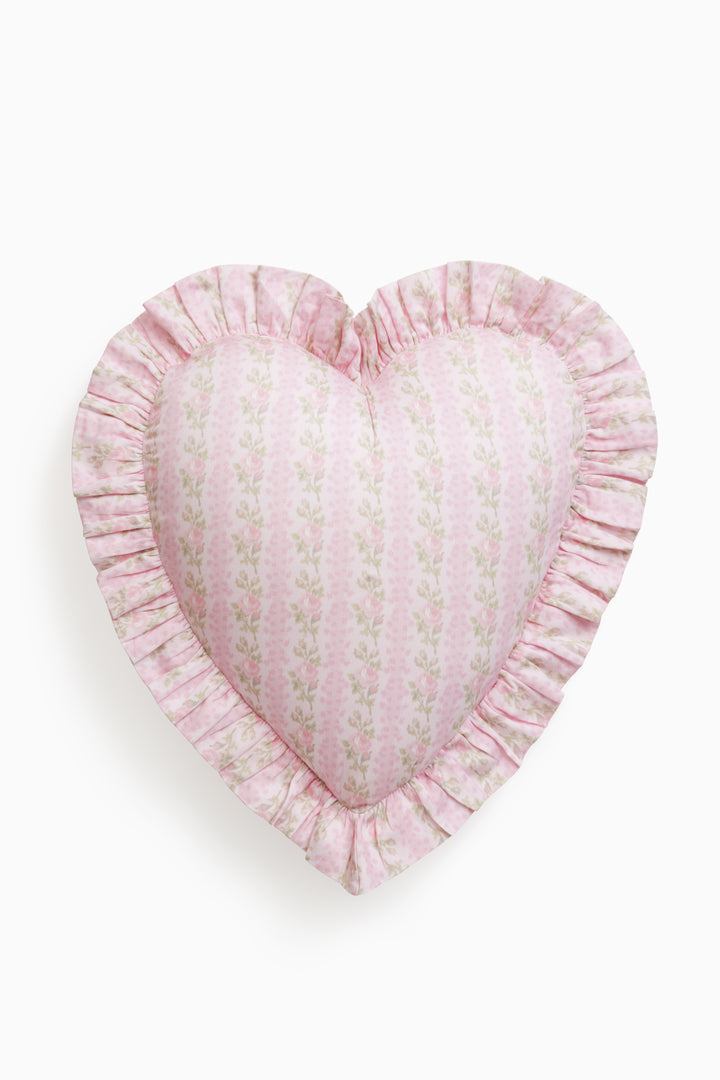 Heart-shaped pink pillow with ruffled edge on a white background