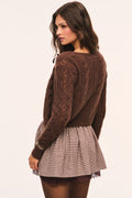 Brown and beige plaid mini skirt with gathered waist and brown lace under layer visible at the hem, back view