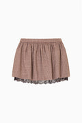 Brown and beige plaid mini skirt with gathered waist and brown lace under layer visible at the hem, detail view
