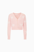 Pink cardigan with bow patterns on a white background