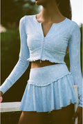 Light blue outfit with long sleeves and a skirt.