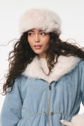 Woman wearing a blue coat with white fur trim and a matching hat on a white background