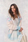 Woman wearing a pastel cardigan with a white background