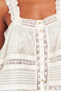 close up image of white embroidered cotton top