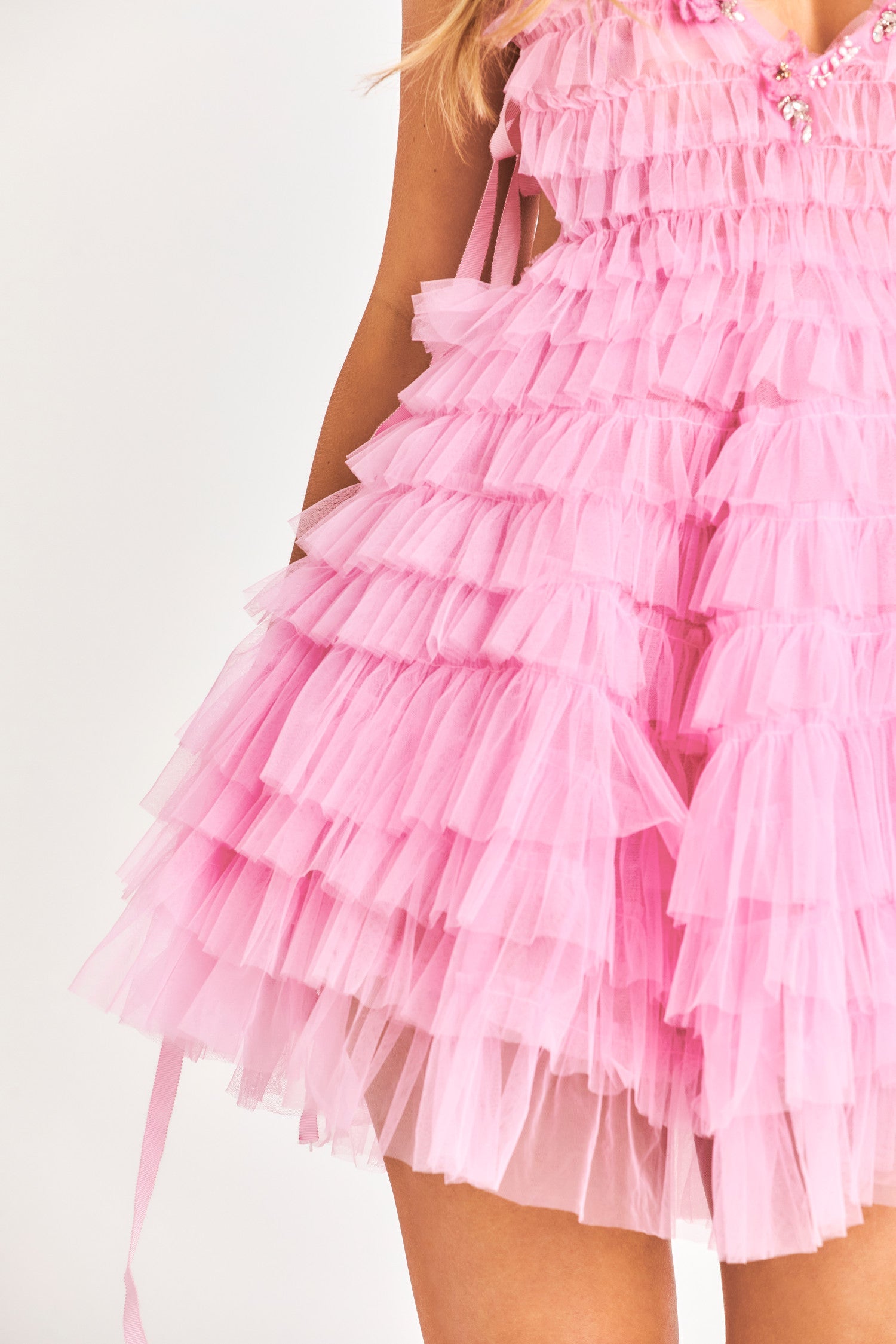 Pink mini dress features tiers of tulle with a plunging v-neckline adorned with rosette appliques and embroideries