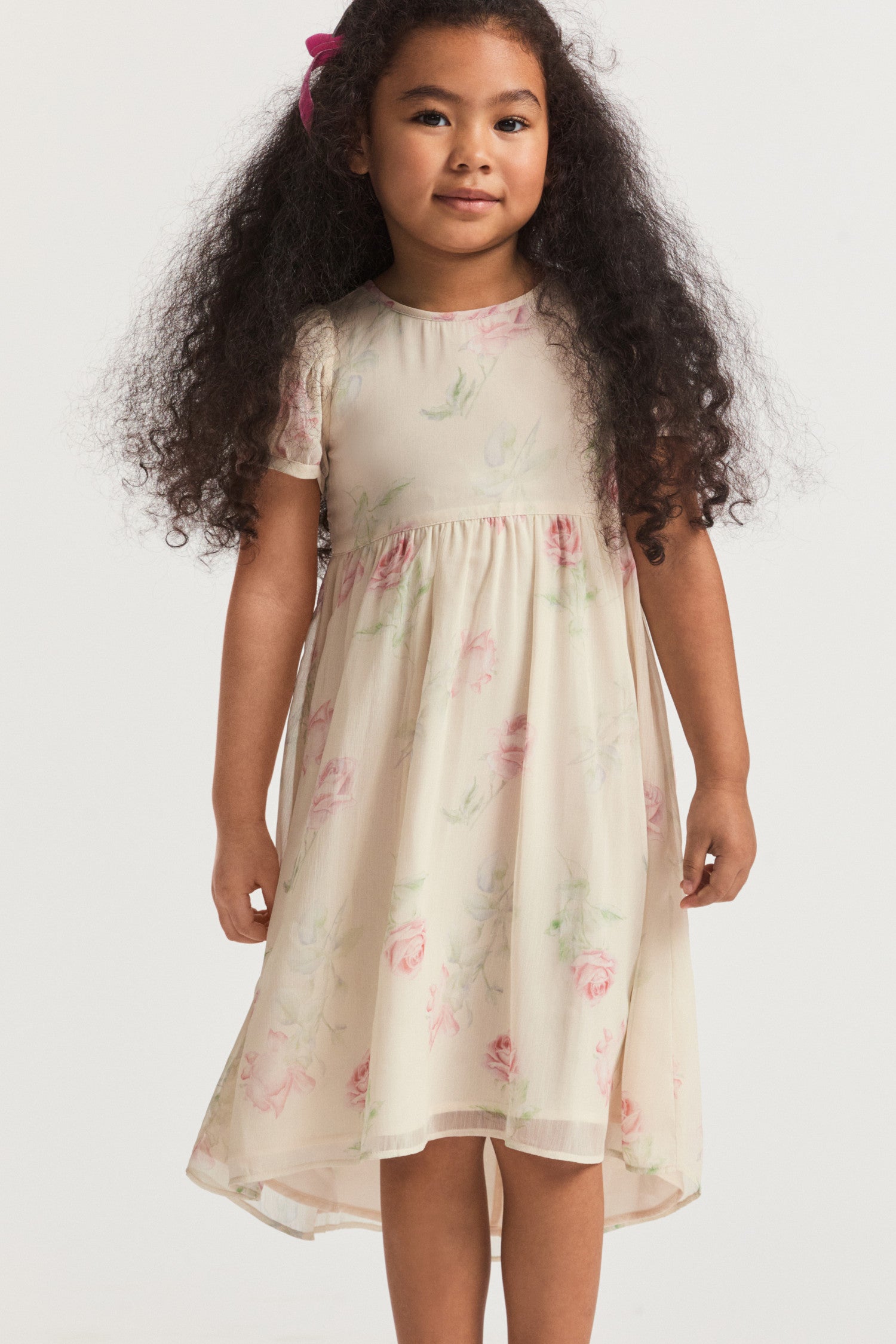 Girls cream floral dress, with sheer puffed sleeves and an empire waist lets down into a full tea-length skirt. Side seam mesh ties extend from the waist to a spirited bow at the back for a sweet touch. Center back button closure.