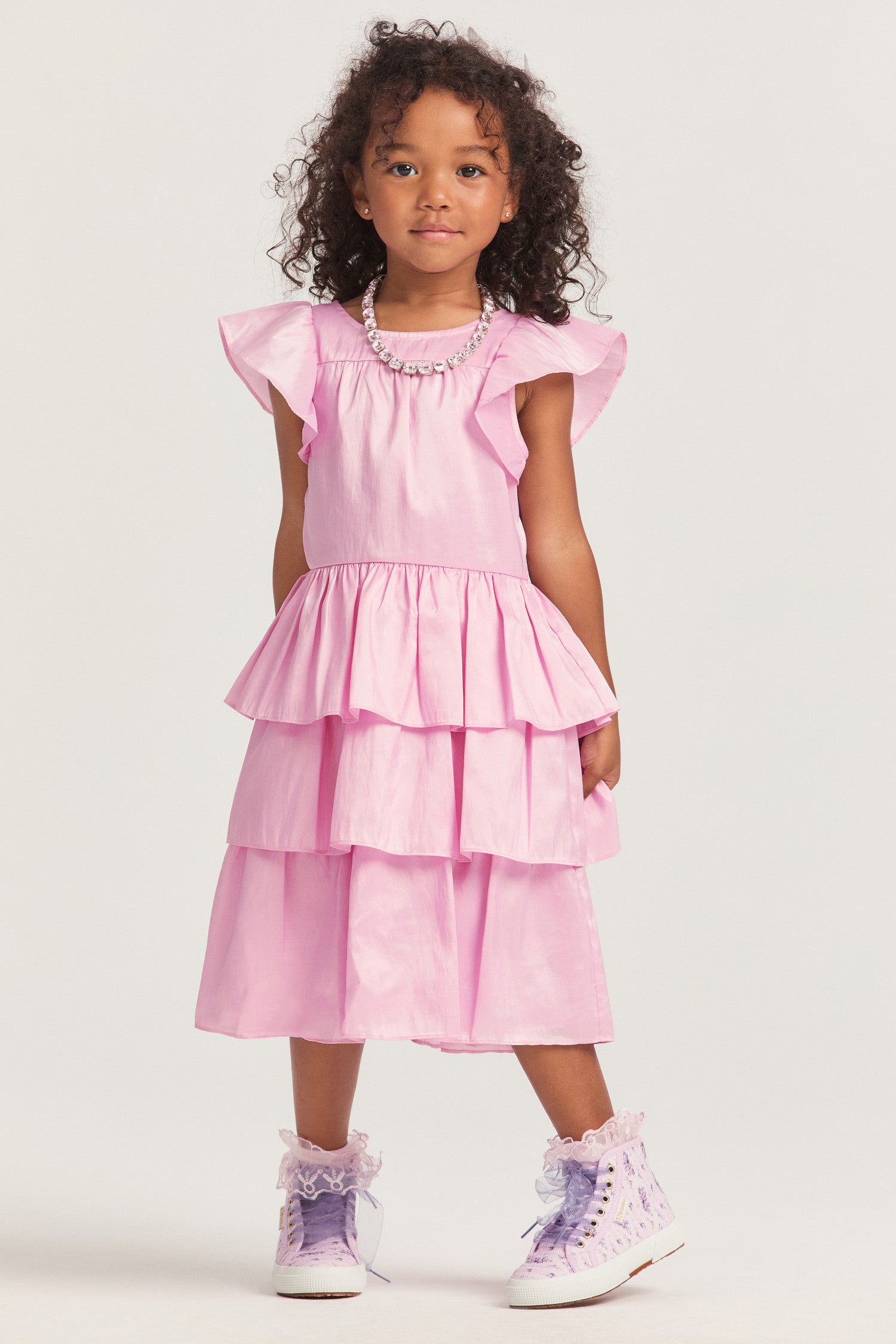 Girls pink dress with nylon fabric, and flutter sleeves frame the roomy bodice. An encased elastic waist lets out into a three-tiered ruffle skirt. 
