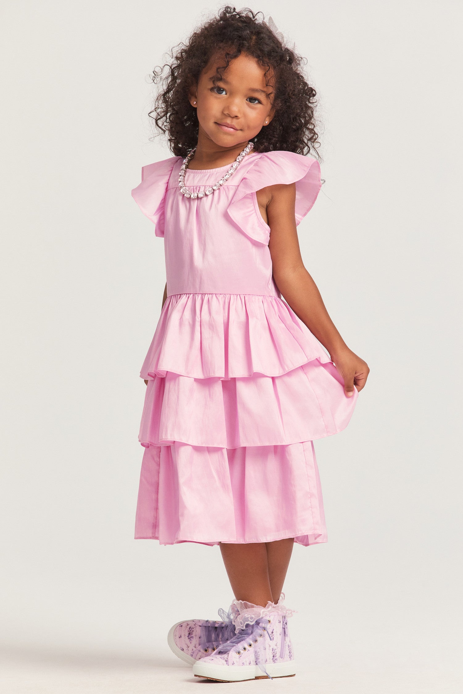 Girls pink dress with nylon fabric, and flutter sleeves frame the roomy bodice. An encased elastic waist lets out into a three-tiered ruffle skirt.
