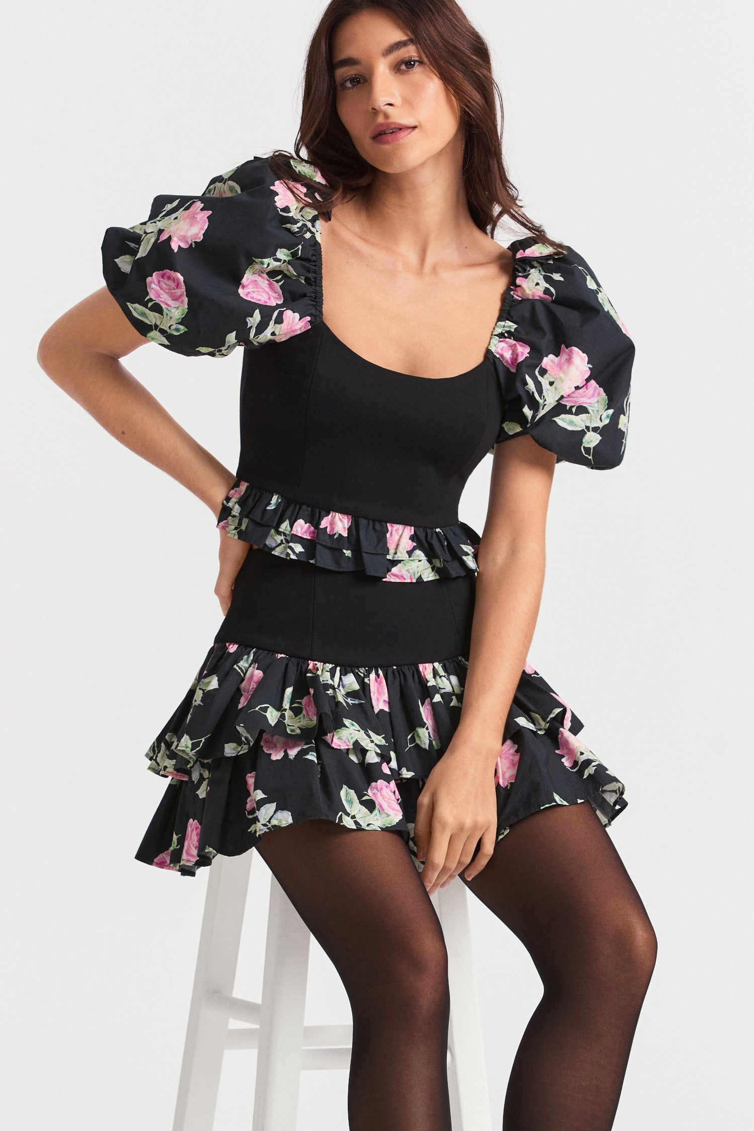Black floral mini skirt with a hip yoke falling to a tiered ruffle skirt. 