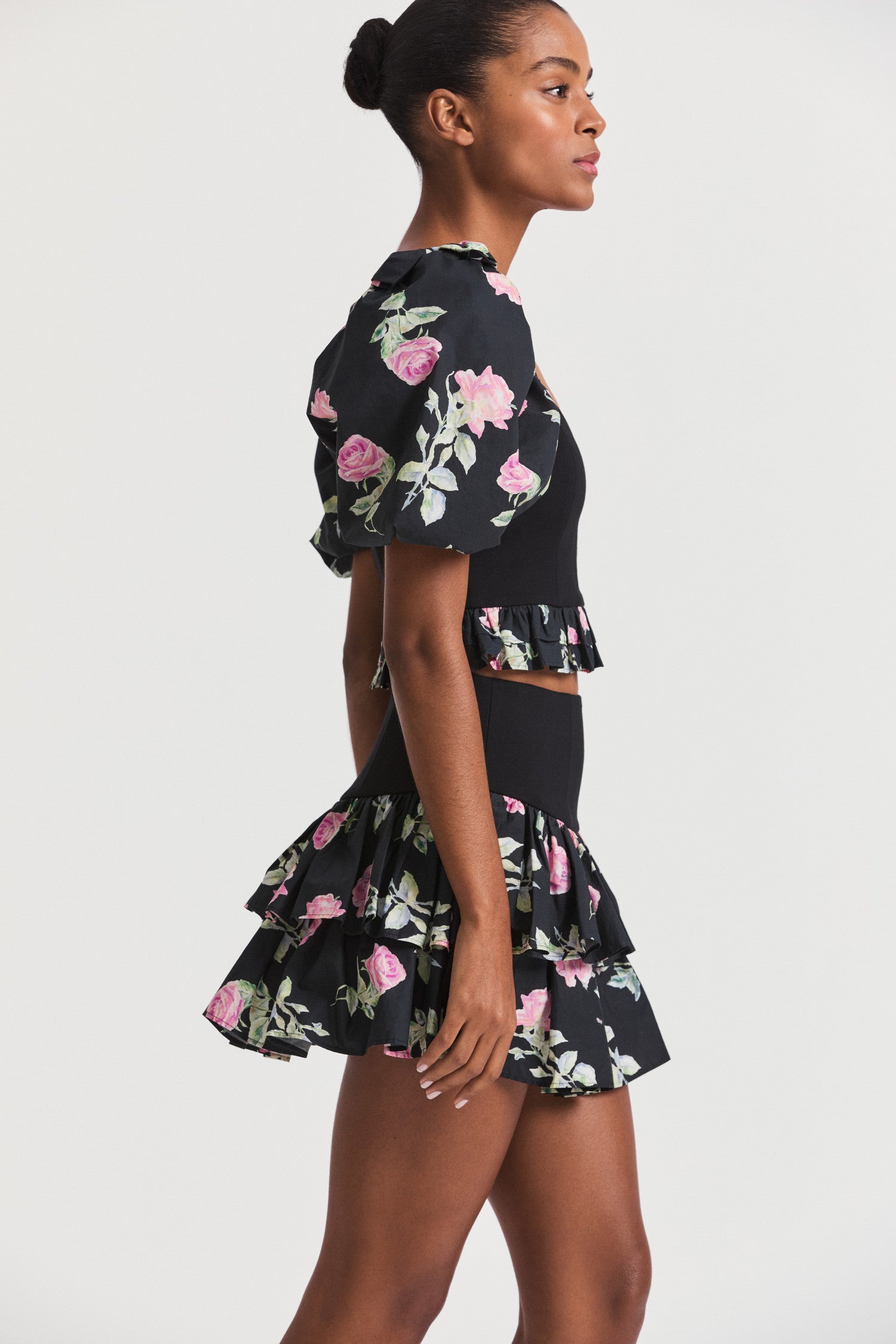 Black floral mini skirt with a hip yoke falling to a tiered ruffle skirt. 