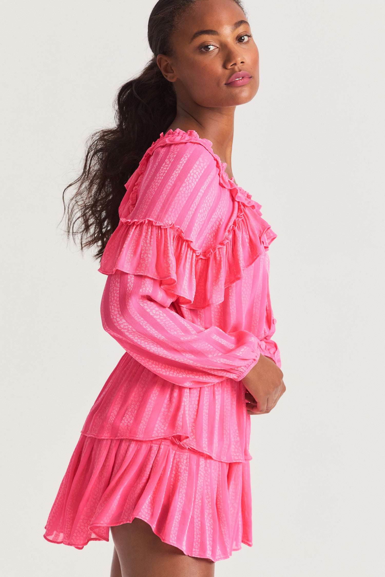 Pink long sleeved-top features a striped jacquard fabric, dramatic ruffles all over, an elasticated waist, elastic at the sleeve openings, and a fully functioning center front slit.