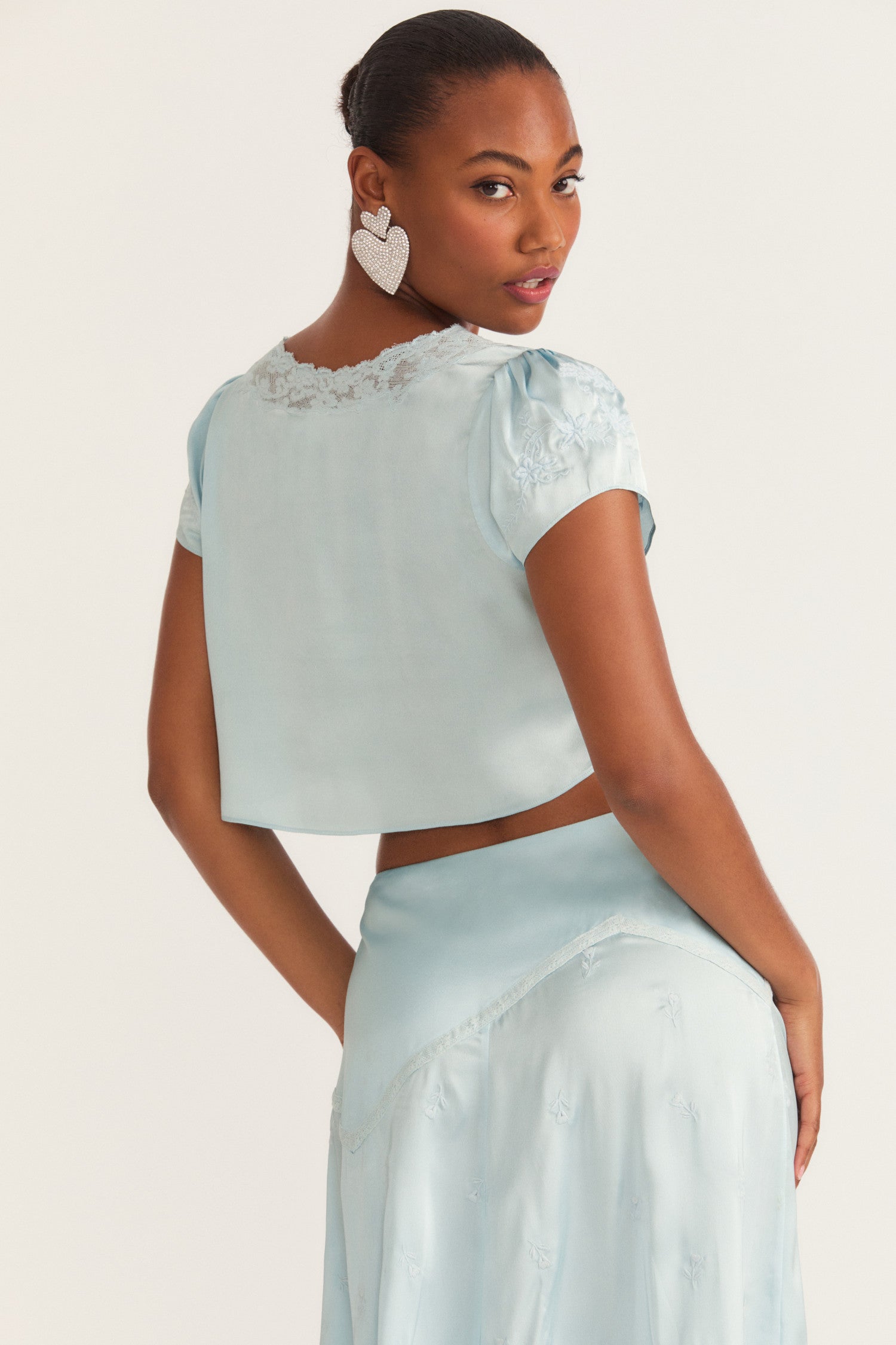Womens blue crop top with custom embroidery and lace detail.