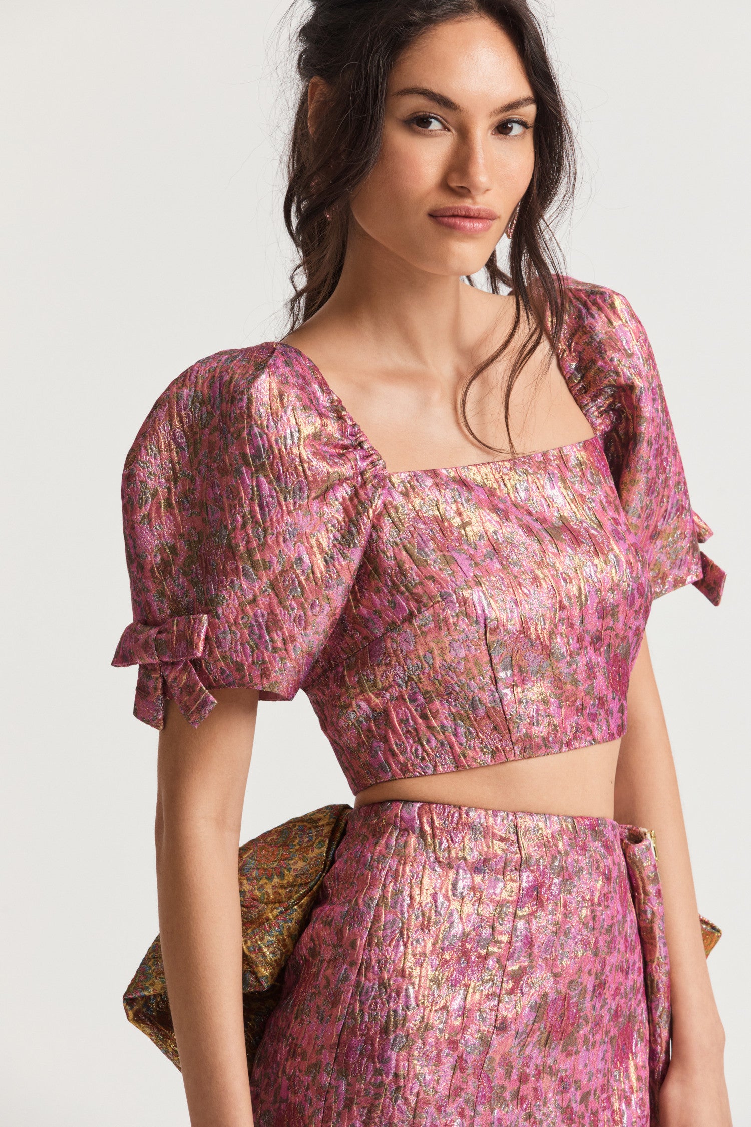  Pink ultra crop top with textural crocheted fabric with and floral print. Puffy sleeves with elastic at the shoulder opening, tiny bows at the sleeves opening, and an exposed zipper at the back bodice. 