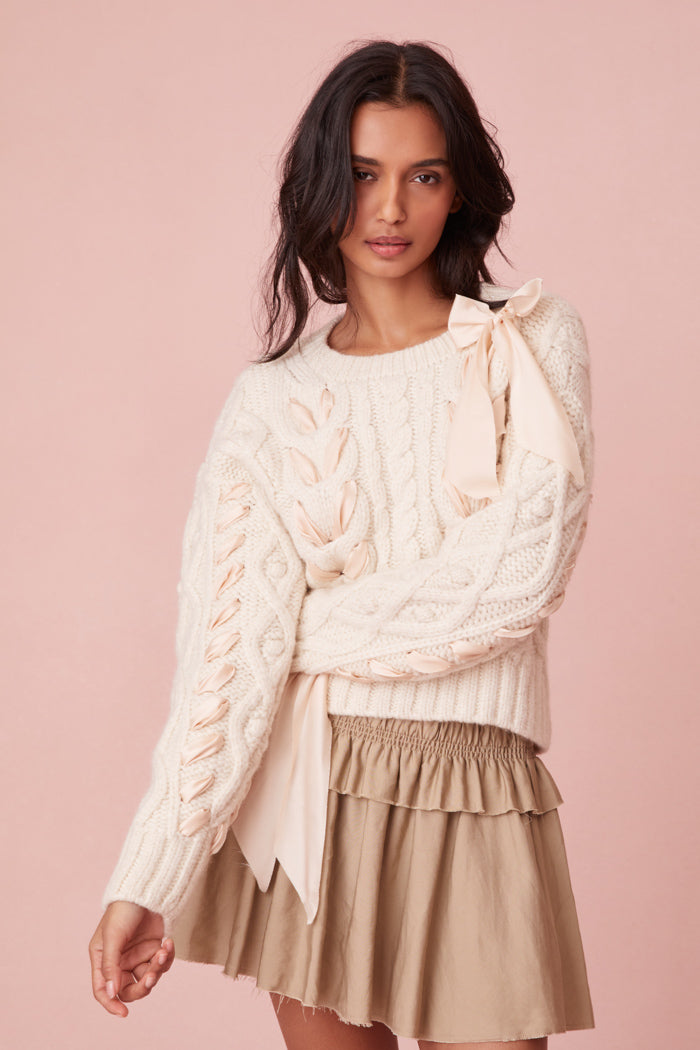 Sweater with chunky Peruvian cable detailing and a charmeuse ribbon threaded throughout.