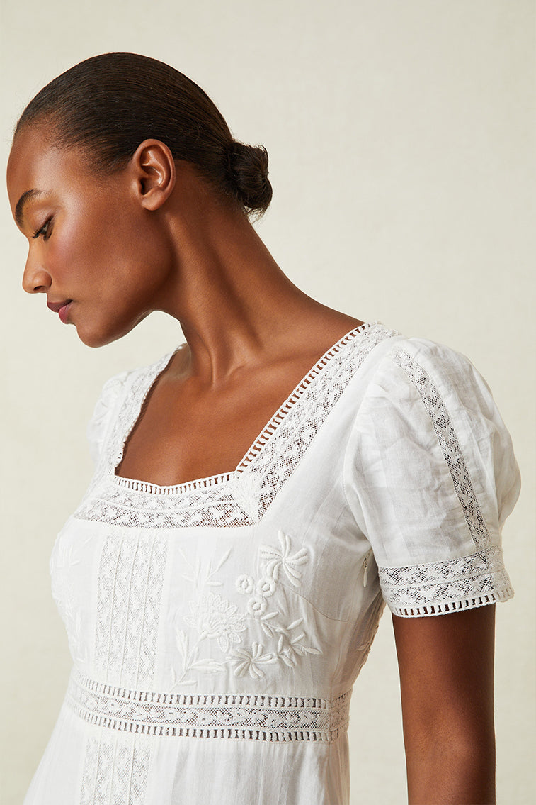 Close up image detailing lace and square neckline on white maxi dress