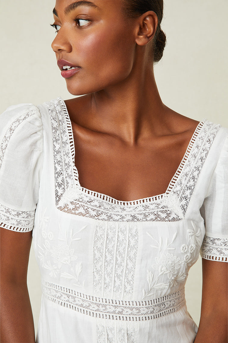 Close up image detailing lace and square neckline on white maxi dress