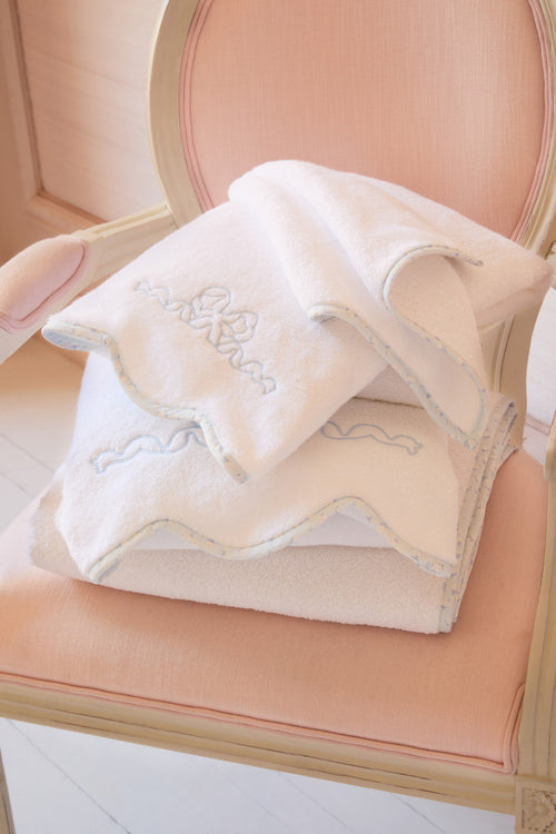 White embroidered towel on a pink chair