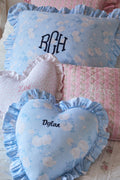 Floral-patterned pillows with ruffles and embroidered names on a soft background