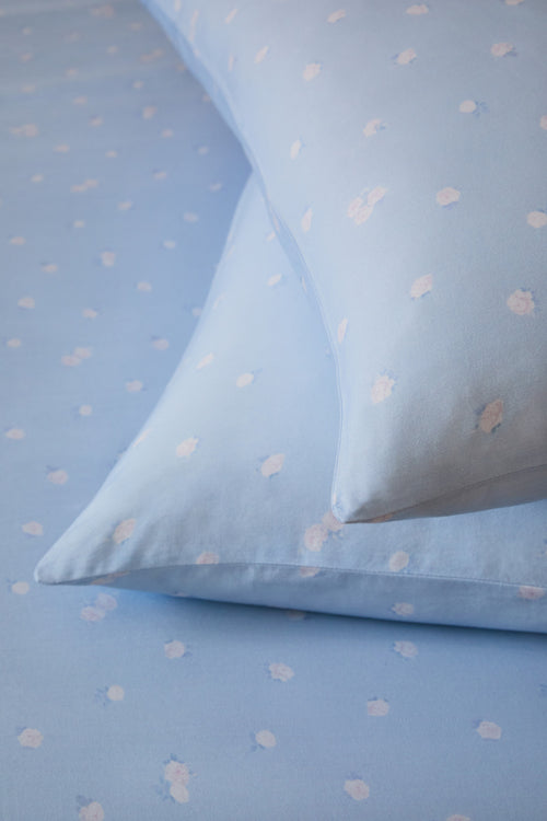 Blue fabric with white floral patterns, resembling a polka dot pattern.