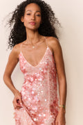 Woman wearing a peach sequin sleeveless midi dress on a white background