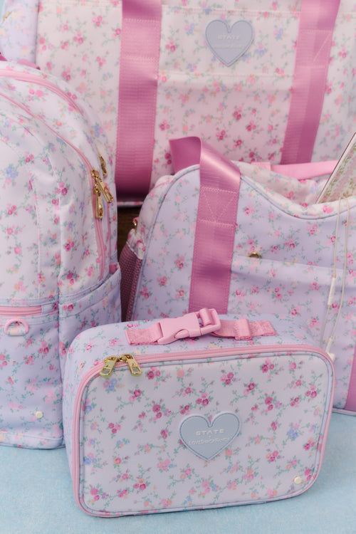 Set of floral-patterned bags with pink ribbons on a light blue background