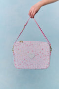 Pink floral laptop bag with a heart design on a light blue background