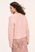 Back view of pink textured knit pullover with ribbed cuffs