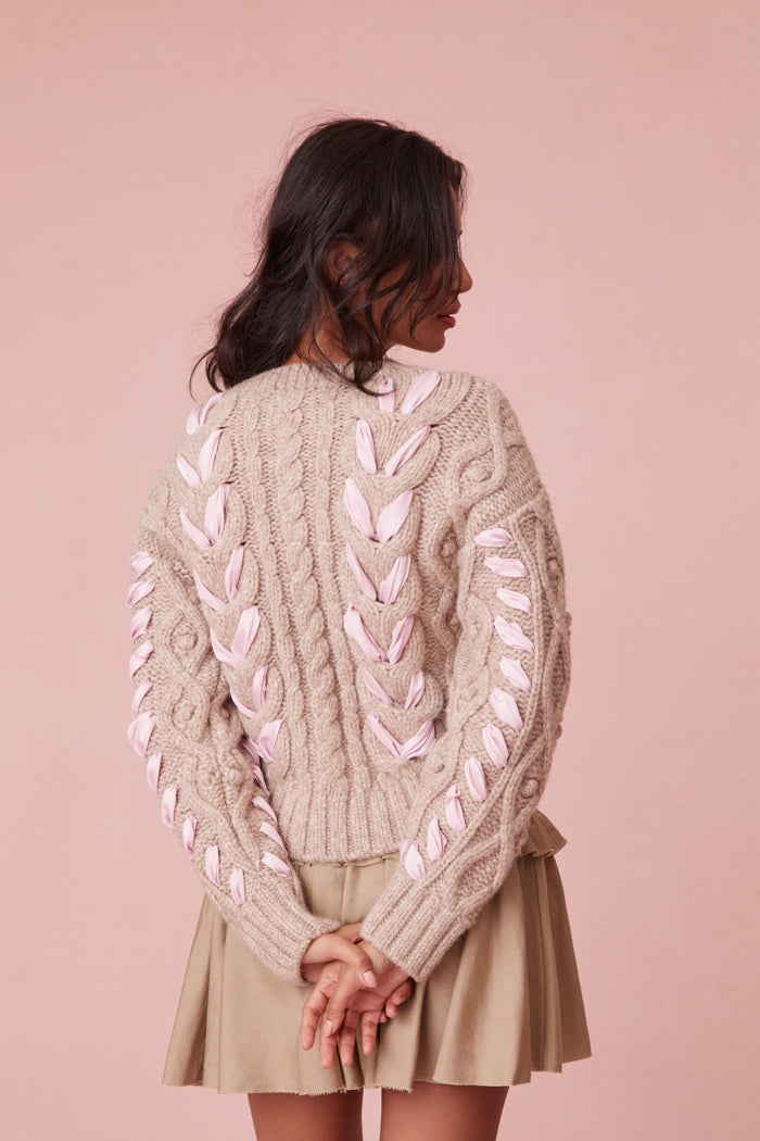 Sweater with chunky Peruvian cable detailing and a charmeuse ribbon threaded throughout.