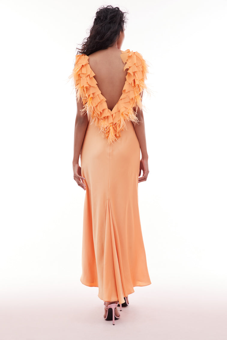 Orange gown with a deep v-neckline and form-fitting skirt featuring an open back adorned with chiffon tatters and ruffles mixed in with accent feathers.