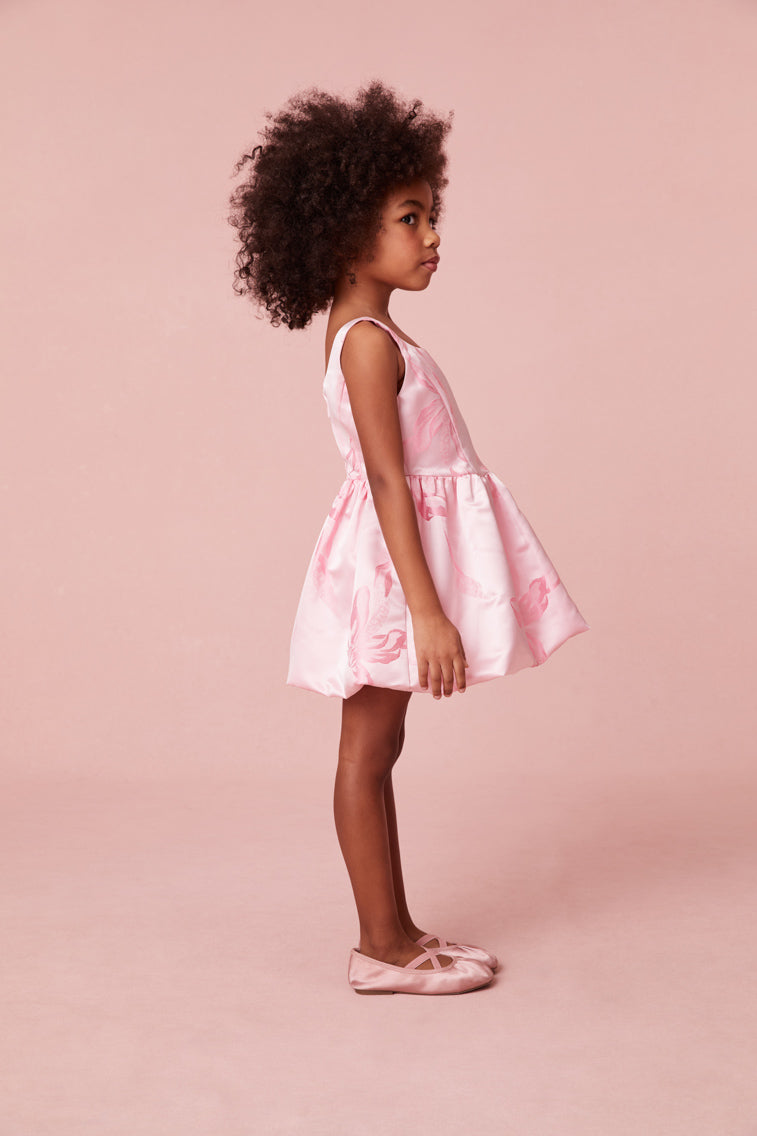 Girls pink dress with tank top straps and a fitted top, falling to a bubble-like skirt.