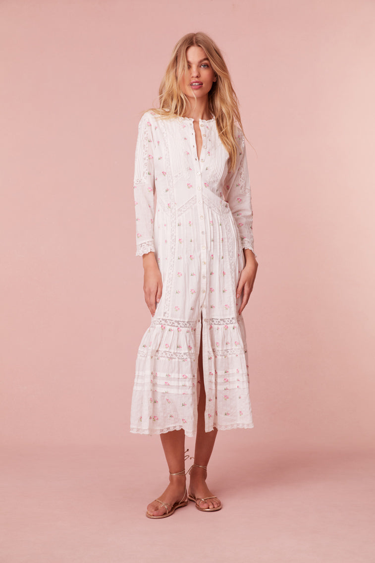 Midi dress embroidered with small pink roses. Completely button down, it begins with three quarter length sleeves before descending to the bodice with pintucking and laces all over.