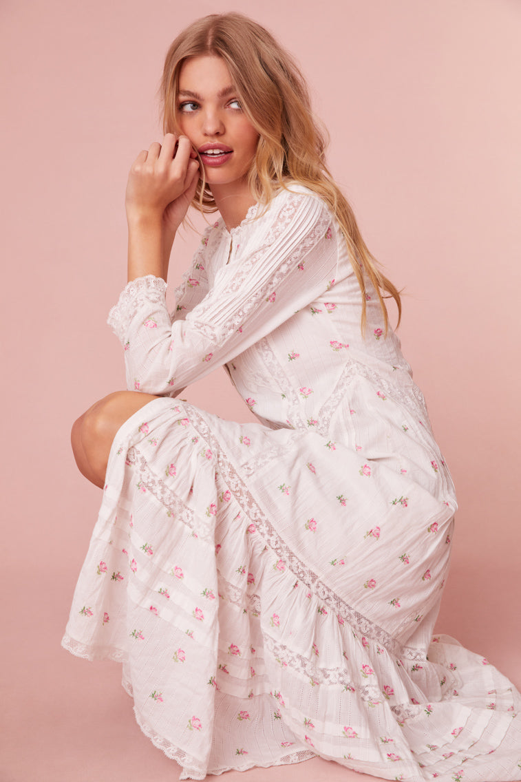 Midi dress embroidered with small pink roses. Completely button down, it begins with three quarter length sleeves before descending to the bodice with pintucking and laces all over.