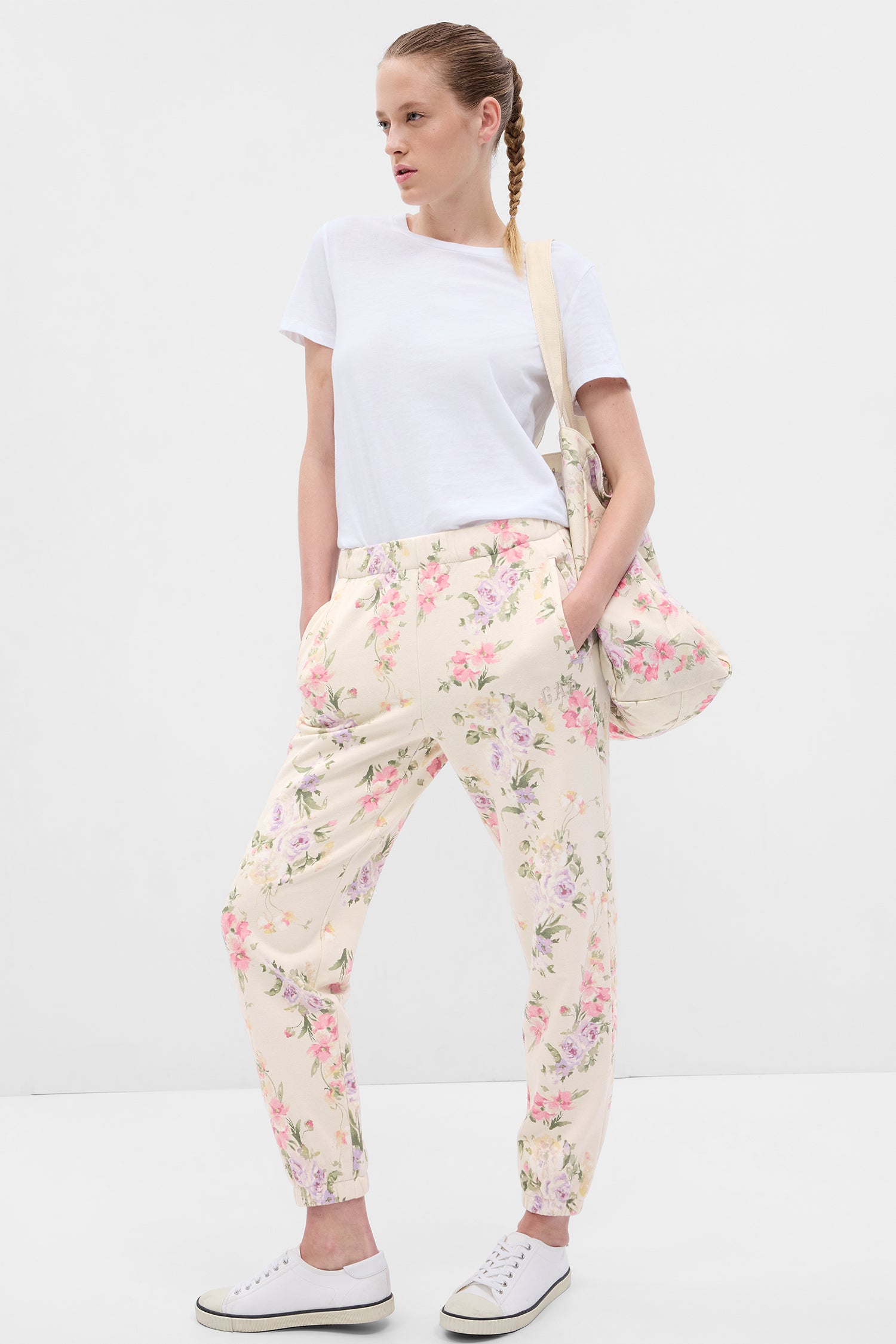Model wearing cream floral joggers with pink, purple, and green floral print