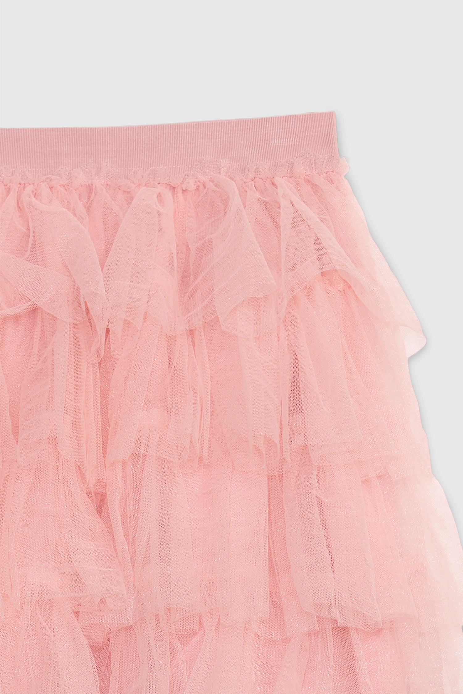 Close up image showing waistband and tulle on kids pink tulle tiered mini skirt with elastic waistband